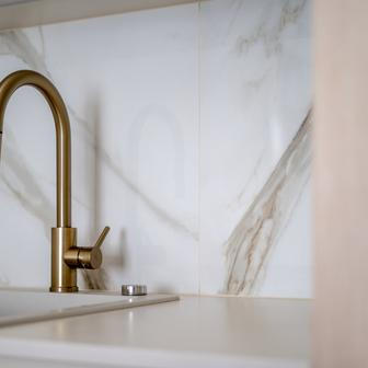 „Mosazné detaily jsme využili napříč celým interiérem – nejen na bateriích a úchytkách, ale i na monturách svítidel,“ dodává Martin Kříž. Právě tyto drobnosti propojují jednotlivé místnosti a dodávají bytu jemný odkaz na jeho původní atmosféru.