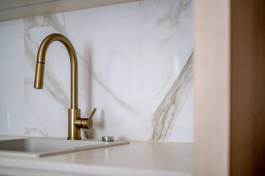 „Mosazné detaily jsme využili napříč celým interiérem – nejen na bateriích a úchytkách, ale i na monturách svítidel,“ dodává Martin Kříž. Právě tyto drobnosti propojují jednotlivé místnosti a dodávají bytu jemný odkaz na jeho původní atmosféru.