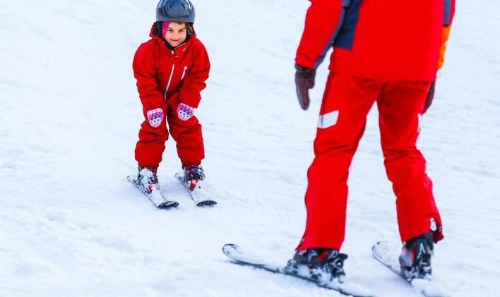Professional,Ski,Instructor,Is,Teaching,A,Child,To,Ski,On