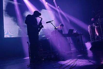 Britský producent Romare (uprostřed) se v Praze obklopil dvěma hudebníky s perkusemi a žesťovými nástroji. Všichni tři pak předvedli silný koncertní set bez přestávek.