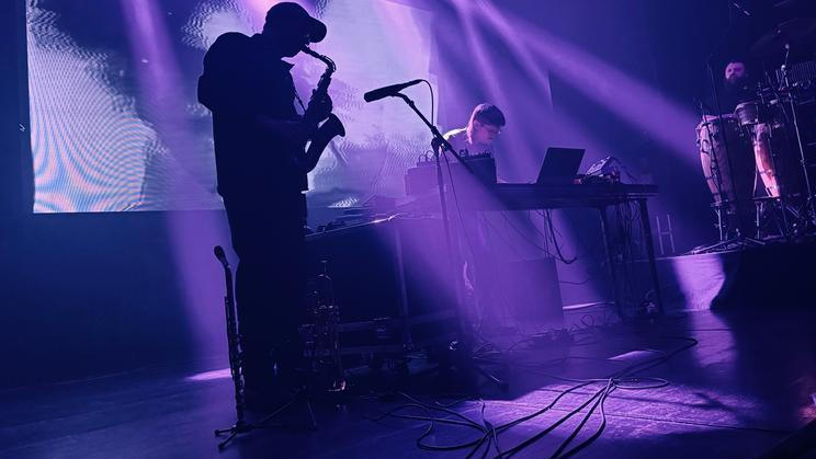 Britský producent Romare (uprostřed) se v Praze obklopil dvěma hudebníky s perkusemi a žesťovými nástroji. Všichni tři pak předvedli silný koncertní set bez přestávek.