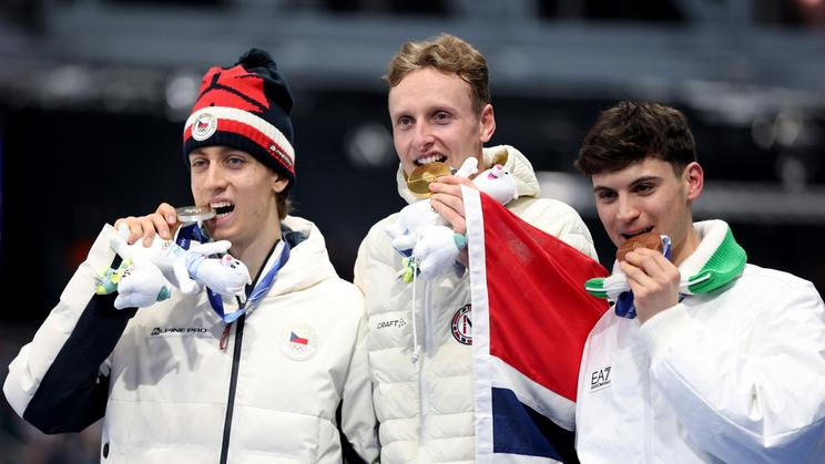 Stříbrný Metoděj Jílek, zlatý  Sander Eitrem a bronzový Riccardo Lorell na stupních vítězů po závodě rychlobruslařů na 5000 m na ZOH 2026