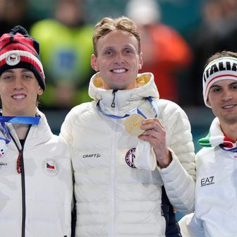 Stříbrný Metoděj Jílek, zlatý  Sander Eitrem a bronzový Riccardo Lorell na stupních vítězů po závodě rychlobruslařů na 5000 m na ZOH 2026