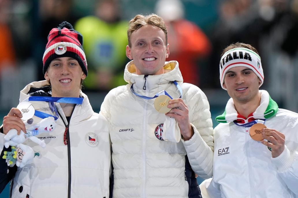 Stříbrný Metoděj Jílek, zlatý  Sander Eitrem a bronzový Riccardo Lorell na stupních vítězů po závodě rychlobruslařů na 5000 m na ZOH 2026