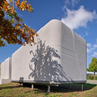 Architekti navrhli formu a funkci, tým české společnosti ICE Industrial Services prostřednictvím své divize Coral Construction Technologies pak převedl návrh do digitálního modelu. A robotická tiskárna začala vrstvu po vrstvě vytvářet nosné stěny přímo na místě stavby.