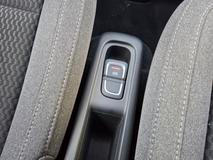 Mezi předními sedadly není příliš místa, tak akorát na tlačítko parkovací brzdy a malý odkládací prostor.