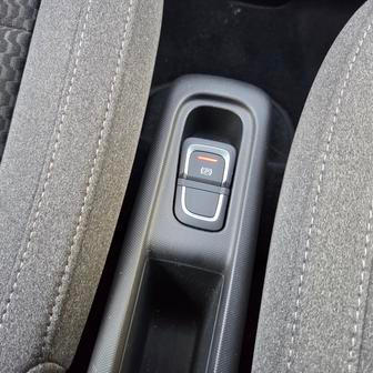 Mezi předními sedadly není příliš místa, tak akorát na tlačítko parkovací brzdy a malý odkládací prostor.