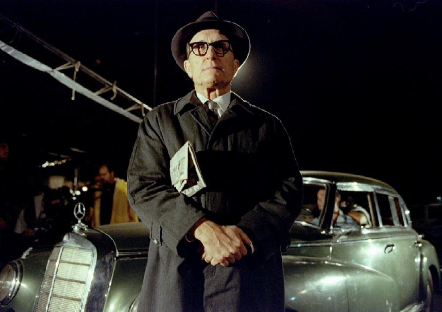 Americký herec Robert Duvall ztvárňující nacistu Adolfa Eichmanna během natáčení filmu „Muž, který chytil Eichmanna". FILE PHOTO: U.S. actor Robert Duvall dons a raincoat and thick-rimmed glasses to portray Nazi Adolf Eichmann dur..