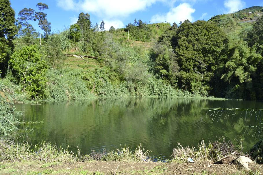 Kráter Sinila na Diengské plošině, dnes klidná vodní hladina, v roce 1979 zdroj smrtícího oxidu uhličitého. Těžký plyn se po erupci tiše rozlil do okolních údolí a připravil o život 149 lidí. Fotografie vznikla před rokem 2017.
