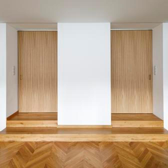 Kuchyně pak přirozeně funguje jako skutečné srdce domu, přičemž přes průchozí spíž propojuje pracovní část s obytným prostorem v přístavbě, kde se jídelna a obývací pokoj otevírají velkorysými výhledy do zahrady. Podkroví zase definují vikýře a sloupky nesoucí vaznicovou soustavu stanové střechy a severozápadní část skrývá koupelnu s tím, že jihovýchodní a jihozápadní sektor patří dětským pokojům. A v domě nechybí ani malý sklad - často opomíjená, ale důležitá součást obydlí.