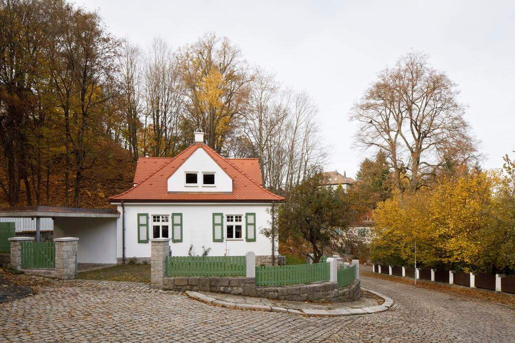 Proto se rozhodli vrátit budově její architektonickou i urbanistickou integritu, přičemž základní bylo odstranit nepůvodní garáž a znovu zdůraznit čtvercovou hmotu. Pro čtyřčlennou rodinu byl však dům příliš malý a podkroví stísněné, a tak povalovaný ateliér vytvořil novou přístavbu, která je nízká a symetricky navazuje na západní stranu původního domku.