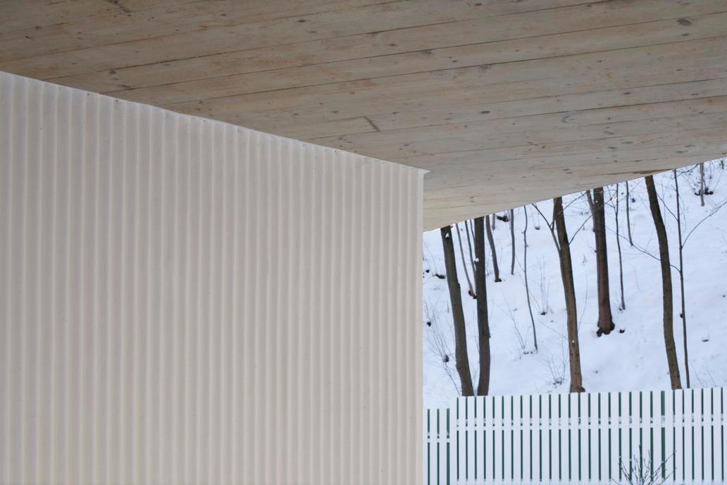 Novotvar přístavby rozdělil zahradu o ploše 591 metrů čtverečních na dva odlišné prostory: přední část zůstává vizuálně propojena s ulicí, zatímco zadní část nabízí intimitu a klid. Přístup k domu i chodník kolem něj jsou pak vyloženy kamenem z místní žuly, terasa za domem zase modřínovými prkny. Přírodní materiály podtrhují dialog mezi historií a současností.