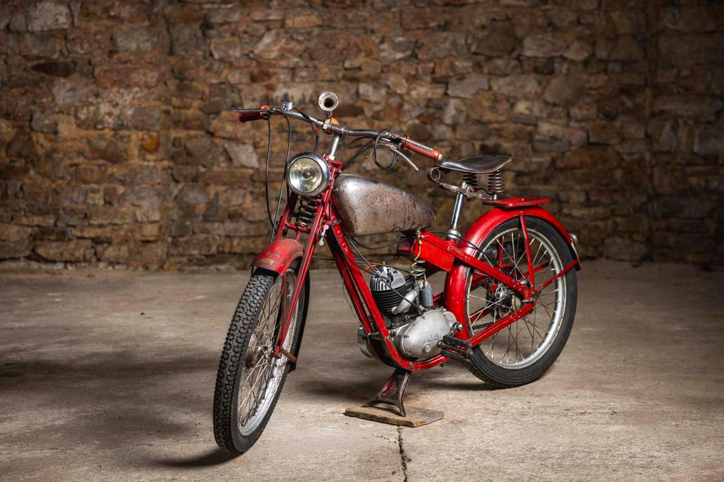 Opakem předchozí motorky je malá Jawa 100 Robot z roku 1939 v původním stavu včetně pneumatik. Vyvolávací cena je 60 tisíc korun.