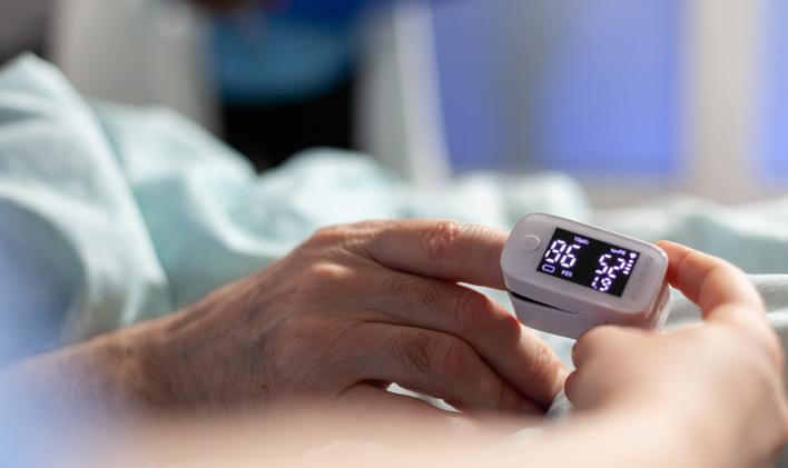 Close up of oxymeter attached on sick senior patient