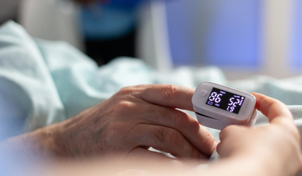 Close up of oxymeter attached on sick senior patient