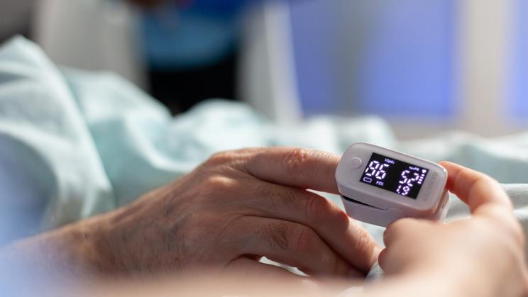 Close up of oxymeter attached on sick senior patient