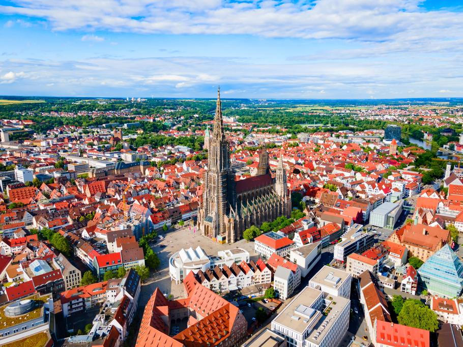 Letecký pohled na Ulm s dominantní katedrálou Ulm Minster, ikonou města známého svou dlouhodobou municipální bytovou politikou.