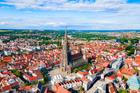 Letecký pohled na Ulm s dominantní katedrálou Ulm Minster, ikonou města známého svou dlouhodobou municipální bytovou politikou.