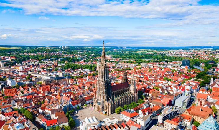 Letecký pohled na Ulm s dominantní katedrálou Ulm Minster, ikonou města známého svou dlouhodobou municipální bytovou politikou.