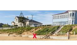 Křížek označuje místo na pláži Somerton v Adelaide, kde bylo 1. prosince 1948 nalezeno tělo neznámého muže, známého jako Somertonský muž. Kolorováno