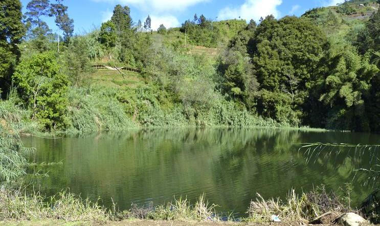 Kráter Sinila na Diengské plošině, dnes klidná vodní hladina, v roce 1979 zdroj smrtícího oxidu uhličitého. Těžký plyn se po erupci tiše rozlil do okolních údolí a připravil o život 149 lidí. Fotografie vznikla před rokem 2017.