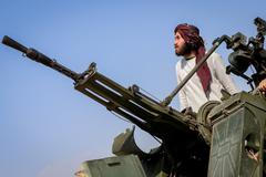 A Taliban soldier stands next to an anti-aircraft gun while on lookout for Pakistani fighter jets, in Khost province