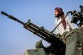 A Taliban soldier stands next to an anti-aircraft gun while on lookout for Pakistani fighter jets, in Khost province