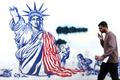 Man walks past mural depicting damaged Statue of Liberty, in Tehran