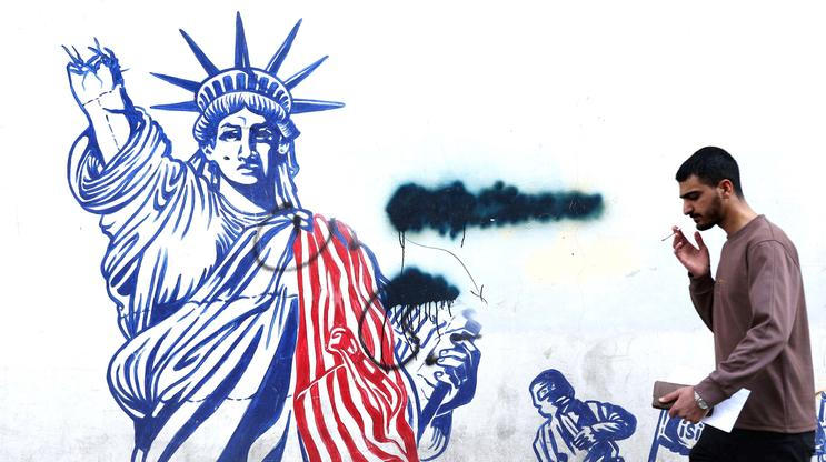 Man walks past mural depicting damaged Statue of Liberty, in Tehran