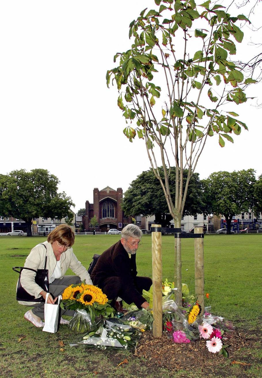 Rodiče Amélie Delagrangeové pokládají květiny u stromu zasazeného na její památku na Twickenham Green v srpnu 2005.