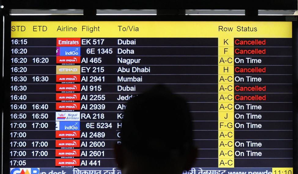 A man views a screen displaying flight information at the Indira Gandhi International airport in New Delhi