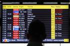 A man views a screen displaying flight information at the Indira Gandhi International airport in New Delhi