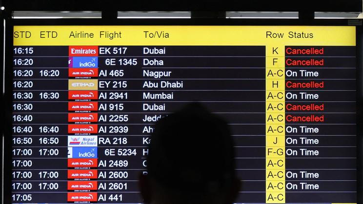 A man views a screen displaying flight information at the Indira Gandhi International airport in New Delhi