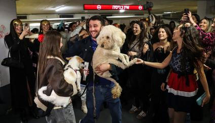 Israelis wear costumes as they attend a party and the reading of the Book of Esther in an underground parking lot functioning as a bomb shelter, during the Jewish holiday of Purim and amid the U.S.-Israel conflict with Iran, in Tel Aviv