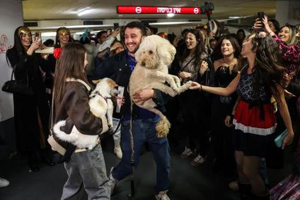 Israelis wear costumes as they attend a party and the reading of the Book of Esther in an underground parking lot functioning as a bomb shelter, during the Jewish holiday of Purim and amid the U.S.-Israel conflict with Iran, in Tel Aviv