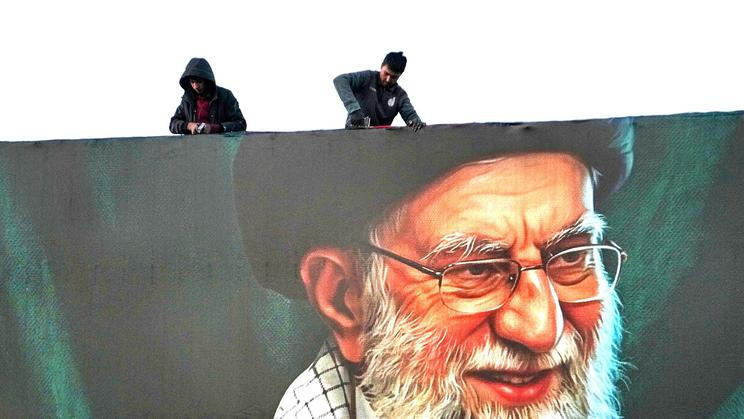 Dělníci instalují obří billboard s tváří ajatolláha Chameneího poté, co ho o víkendu izraelské síly zabily během leteckého útoku na Teherán