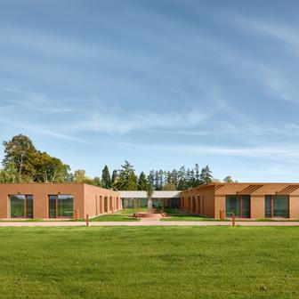 Architekt David Kraus ji navrhl jako klidnou přízemní stavbu, která spíše splývá s okolím, než aby se snažila dominovat prostoru.