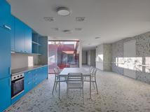 Přivádějí do budovy denní světlo a zároveň fungují jako přirozené společné prostory jednotlivých domácností.