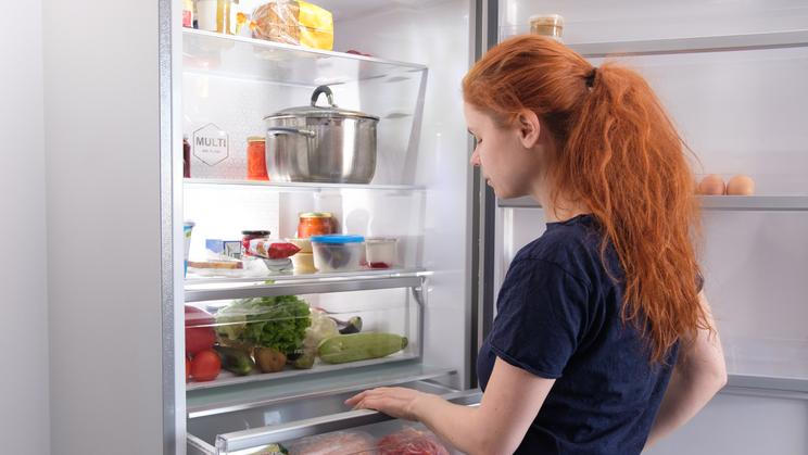 Hungry,Woman,Looking,For,Food,In,Kitchen,At,Home