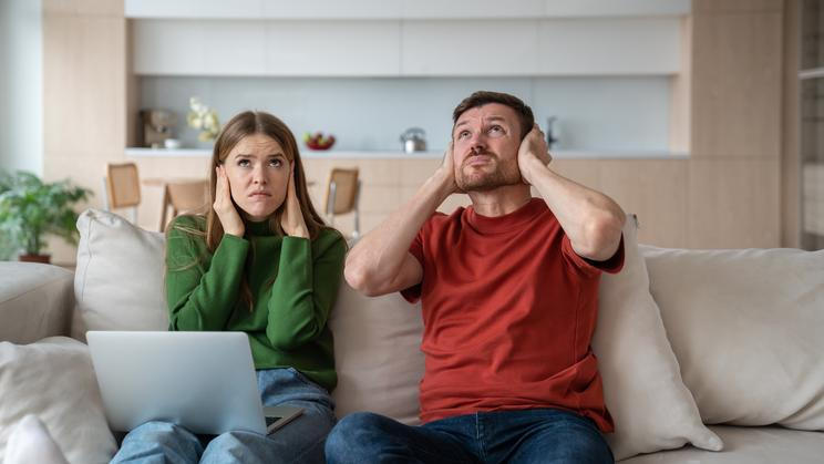 Annoyed,Unhappy,Couple,Sitting,On,Sofa,With,Vexed,Face,Expression,