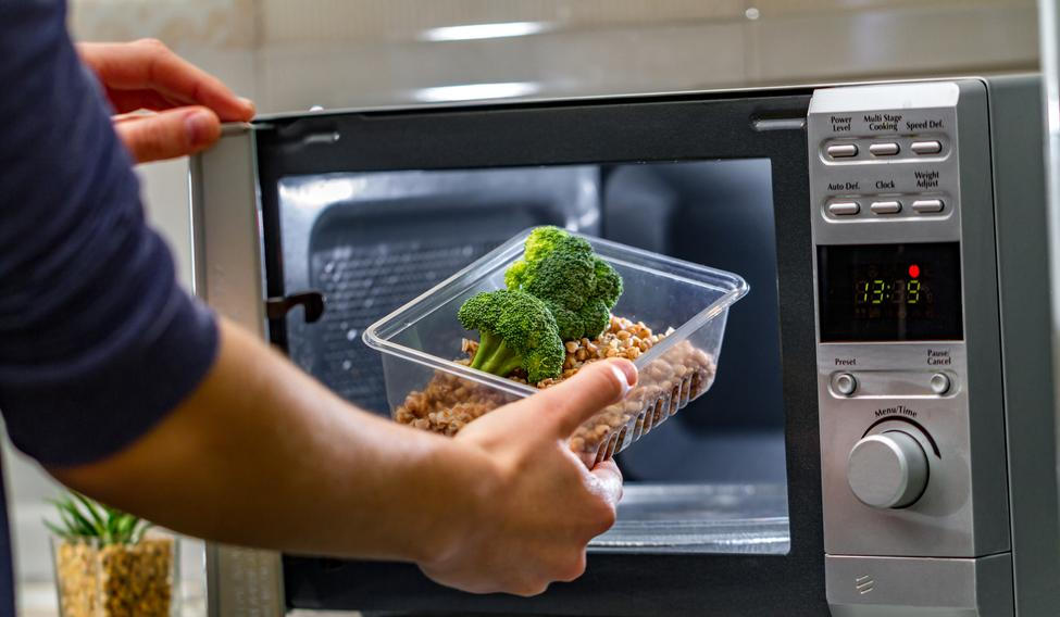 Using,The,Microwave,Oven,To,Heat,Food.,Woman's,Hand,Puts