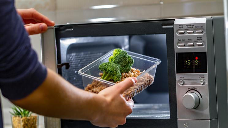 Using,The,Microwave,Oven,To,Heat,Food.,Woman's,Hand,Puts