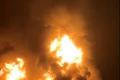 A ship is illuminated by fire from a burning vessel, after Iranian explosive-laden boats appear to have attacked two fuel tankers in Iraqi waters setting them ablaze