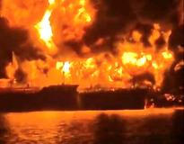A ship burns, after Iranian explosive-laden boats appear to have attacked two fuel tankers in Iraqi waters setting them ablaze