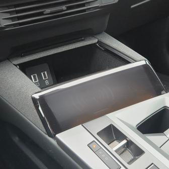 Některé detaily interiéru nás ale vyloženě štvaly. Třeba bezdrátové nabíjení chytrých telefonů pod nevzhledným plastovým krytem.