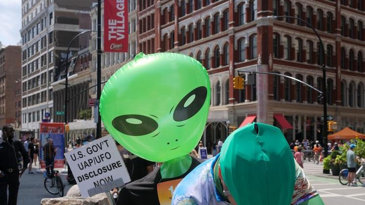 Účastník demonstrace požadující zveřejnění všech informací, které má vláda USA o UFO (New York 2025).
