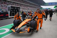 Mechanici McLarenu tlačí monopost Oscara Piastriho do boxů v Šanghaji