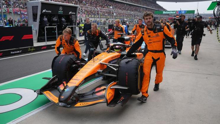Mechanici McLarenu tlačí monopost Oscara Piastriho do boxů v Šanghaji