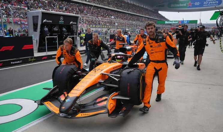 Mechanici McLarenu tlačí monopost Oscara Piastriho do boxů v Šanghaji