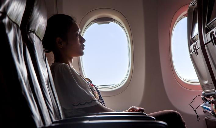 Woman,Sitting,In,A,Flying,Aircraft,And,Watching,The,Monitor.